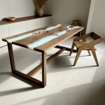 Эксклюзивный обеденный стол из массива грецкого ореха и белой эпоксидной смолы  в светлом интерьере скандинавской столовой.