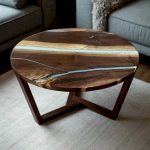 Эксклюзивный круглый журнальный столик из чёрного ореха с белой эпоксидной смолой река на светлом фоне гостиной.