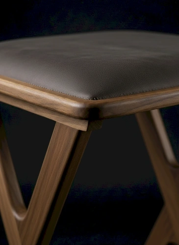 Крупный план прямоугольного мягкого сиденья табурета со скругленными углами, обитого серой экокожей