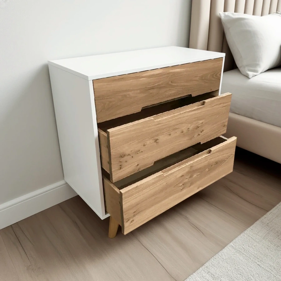 Белый комод из массива карагача  с выдвижными ящиками в светлой спальне в скандинавском стиле.