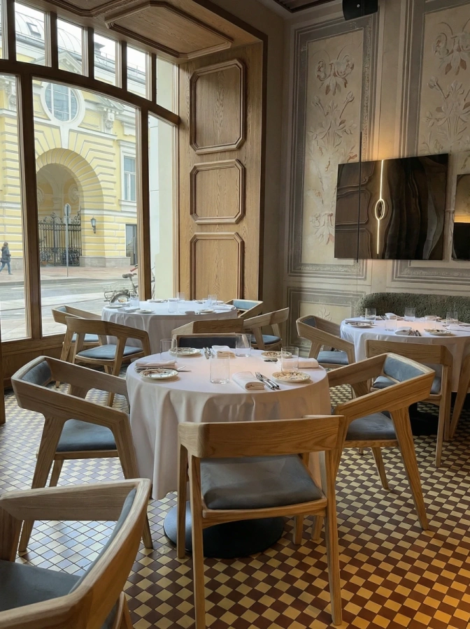 HoReCa. Четыре одинаковых стула из массива дерева вокруг обеденного стола в ремторане в стиле модерн