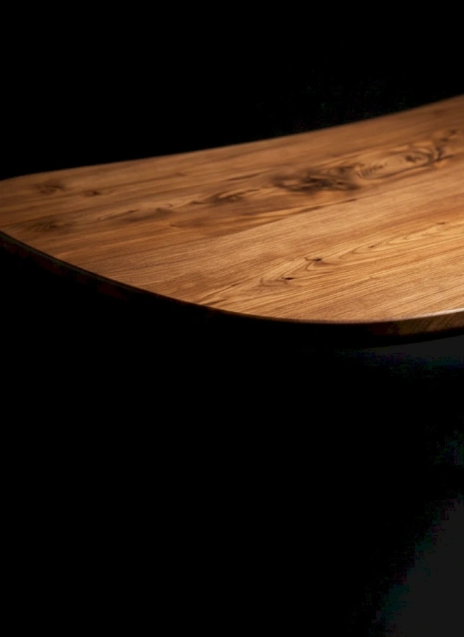 Глянцевая поверхность стола Bean, обработанная маслом и водным лаком, отражает свет.