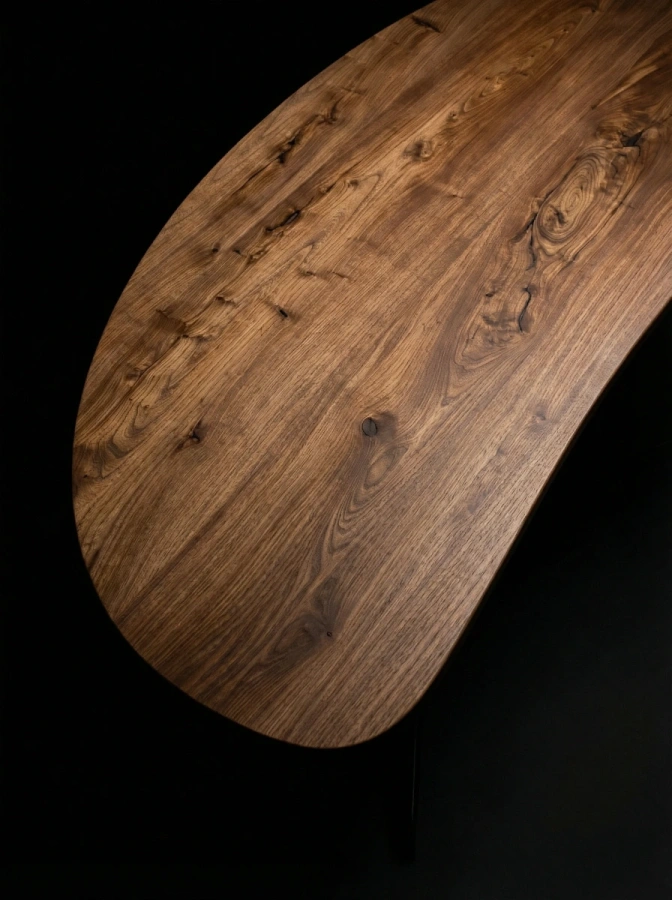 Крупный план столешницы стола Bean: текстура массива карагача и пролитая эпоксидная смола.