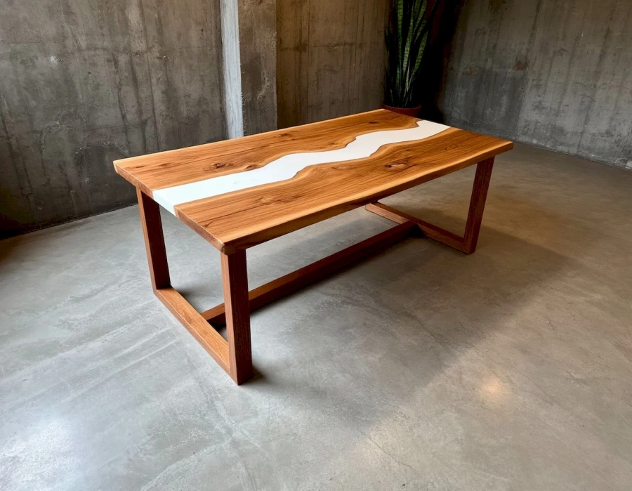 Обеденный стол с эпоксидной рекой в интерьере индустриального стиля с бетонной стеной