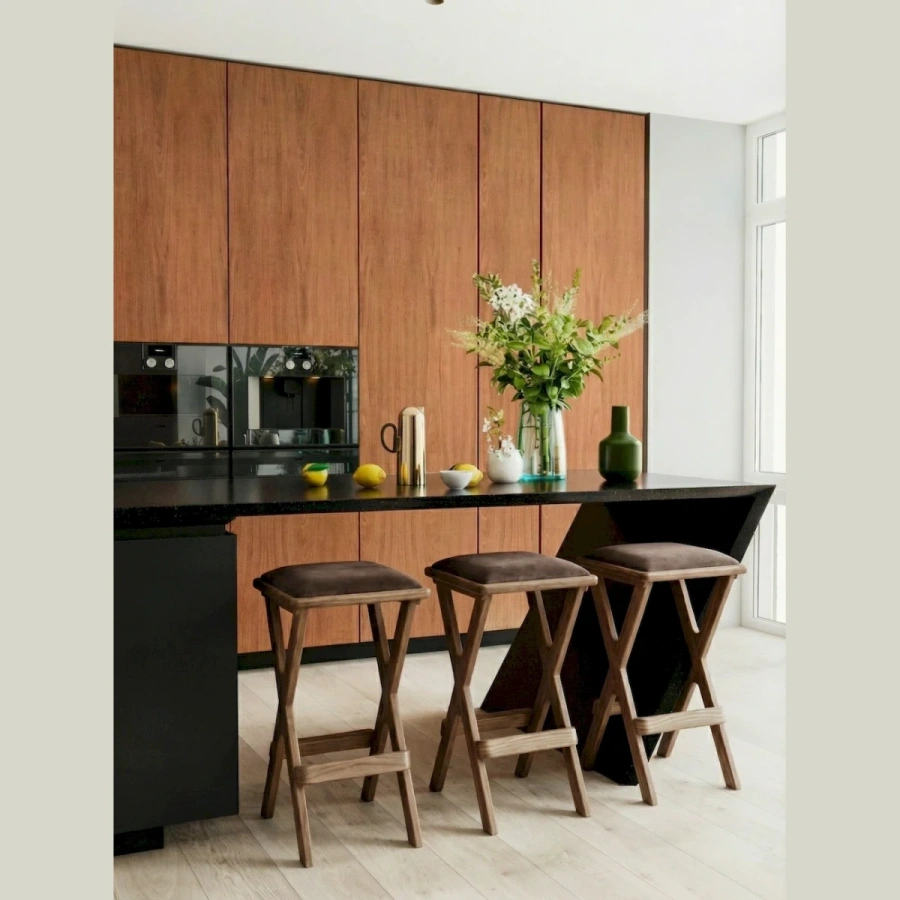 Пара деревянных барных табуретов у высокой столешницы в современной гостиной-столовой