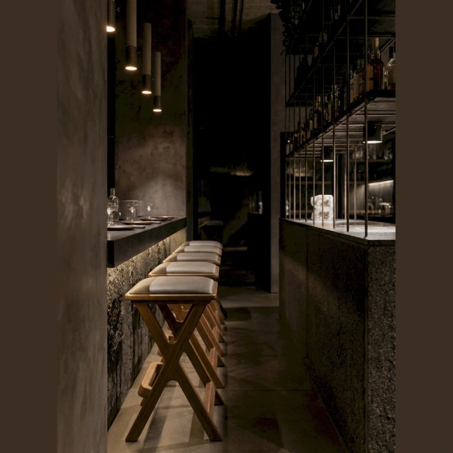 Дизайнерский табурет из массива у барной стойки в индустриальном интерьере лофт с кирпичной стеной