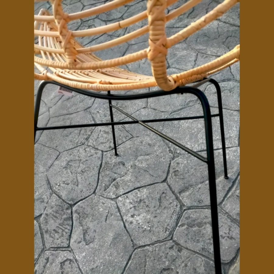 Крупный план плетения искусственного ротанга и черной металлической ножки кресла