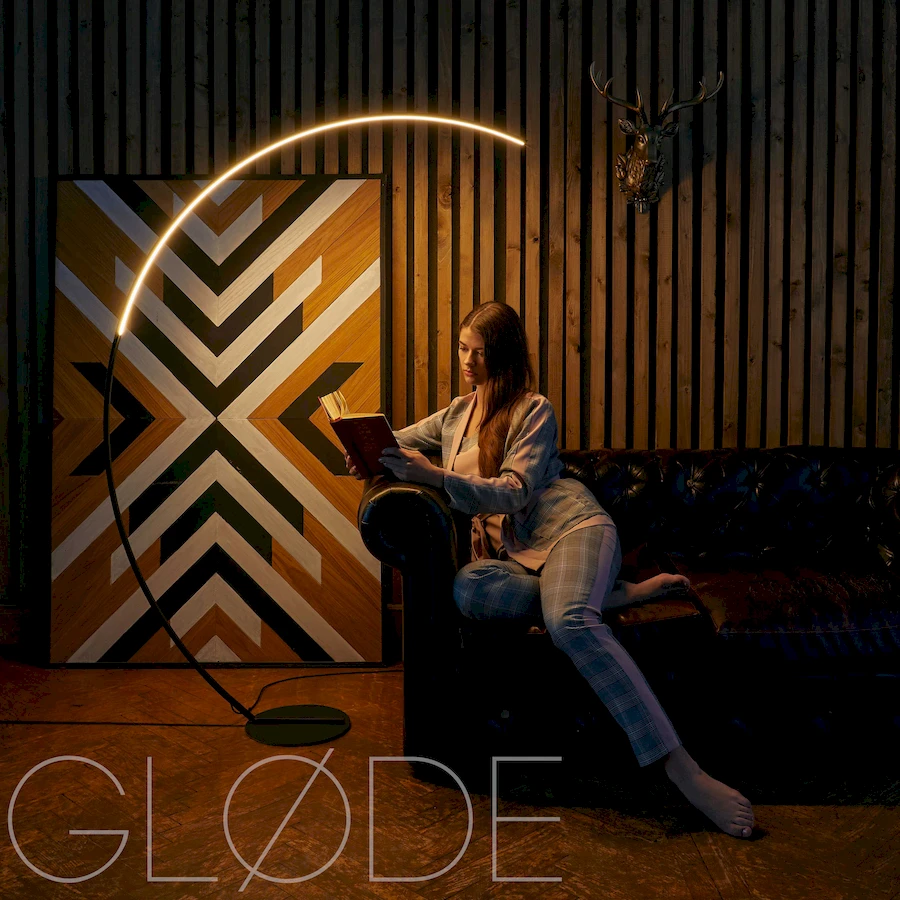 Современный торшер ArcOsmo с дугообразной алюминиевой стойкой в интерьере с девушкой