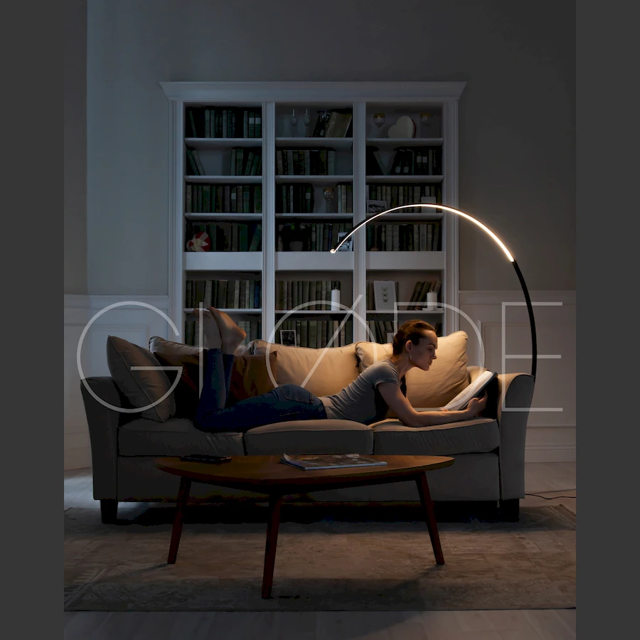 Теплый свет торшера ArcOsmo, установленного рядом с книжным шкафом для комфортного чтения в кабинете 