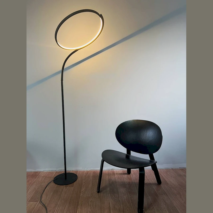 Стильный торшер CircleLine рядом с кроватью в современной спальне, создающий уютное освещение